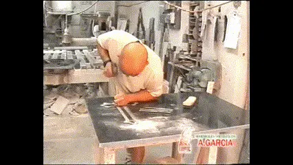 Maestro marmolista de Mármoles A. García grabando a mano sobre una plancha de mármol en el taller